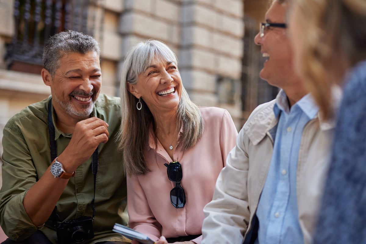 Mature multiethnic friends laughing and talking together in a warm, supportive community